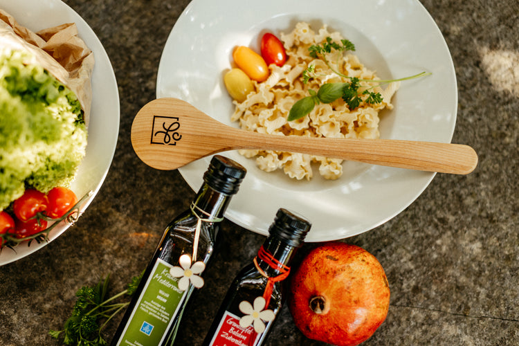 Campanelle Pasta auf Teller mit Holzlöffel in sommerlichem Ambiente