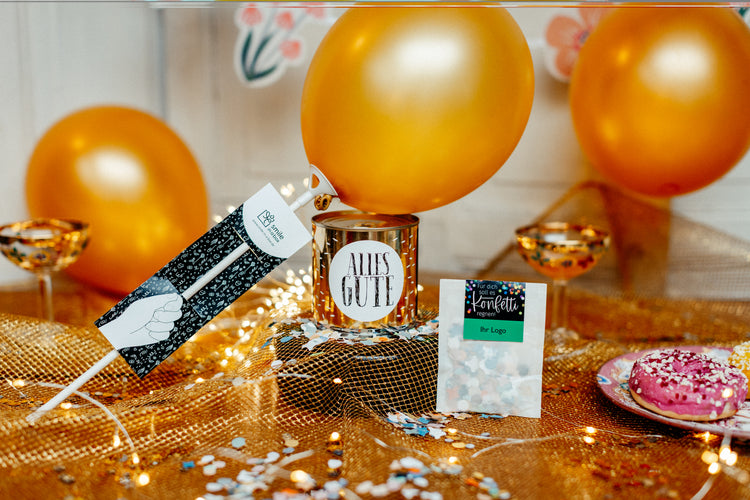 Schmeißen Sie eine Mini Party für liebe Kollegen und treue Kunden - mit Luftballon, Cancake-Kuchen und Konfetti.