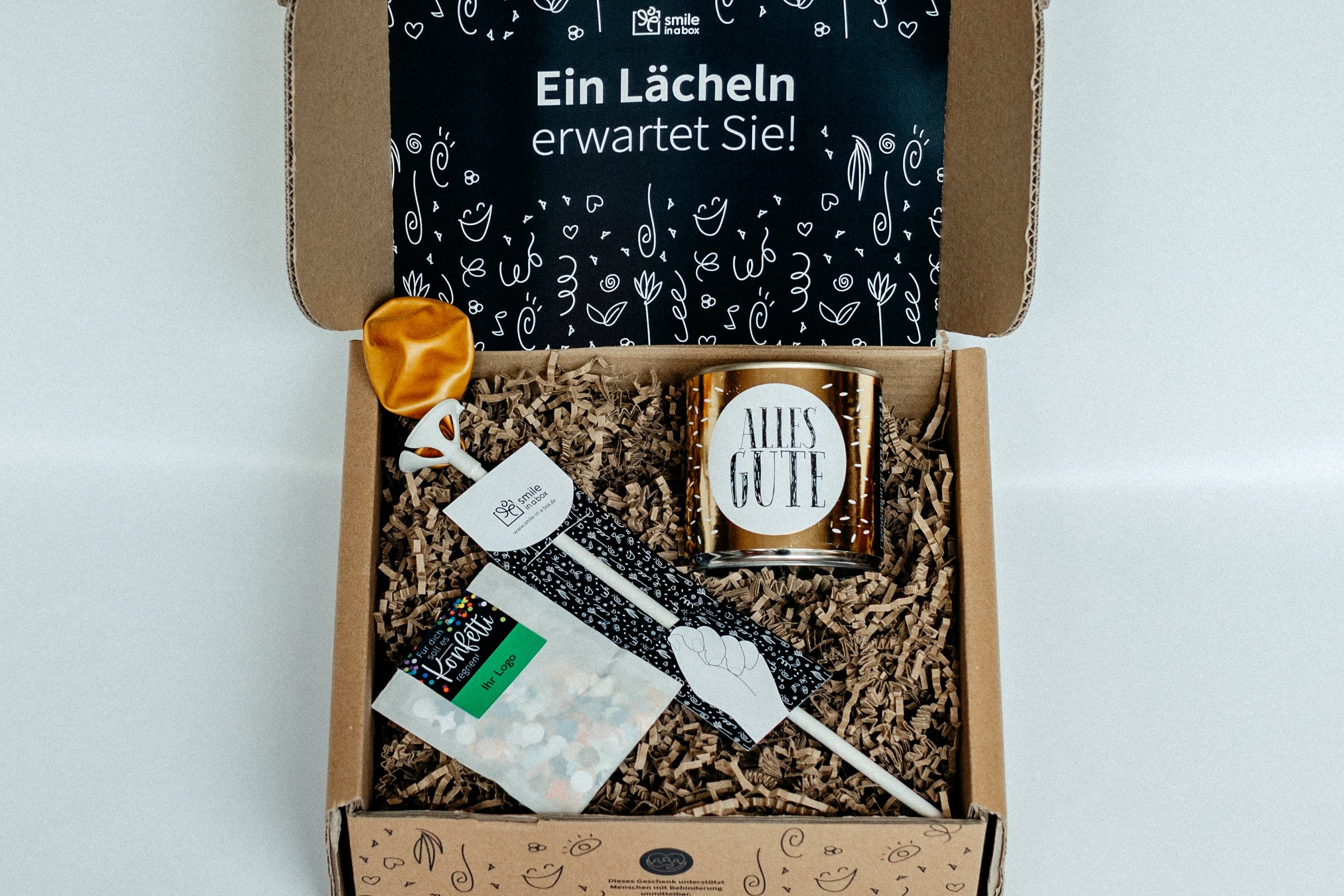 Geschenkbox mit Luftballon, Cancake-Kuchen und Konfetti.