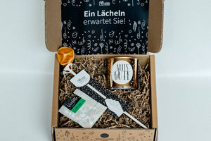 Geschenkbox mit Luftballon, Cancake-Kuchen und Konfetti.