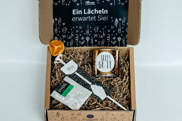 Geschenkbox mit Luftballon, Cancake-Kuchen und Konfetti.