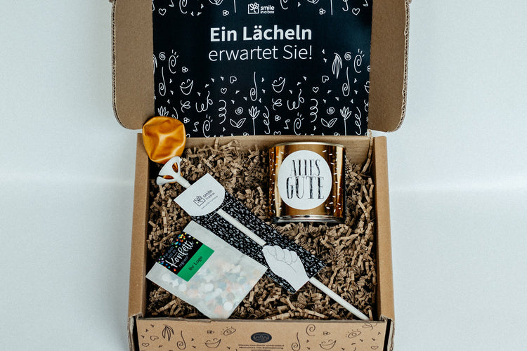 Geschenkbox mit Luftballon, Cancake-Kuchen und Konfetti.