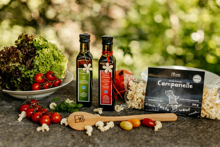 Sommerliche Geschenkbox mit Kräuteröl, Balsamicoessig, Kochlöffel, Pasta mediterran im Gartenflair angerichtet - Ein Geschenk perfekt für Kunden und Mitarbeiter