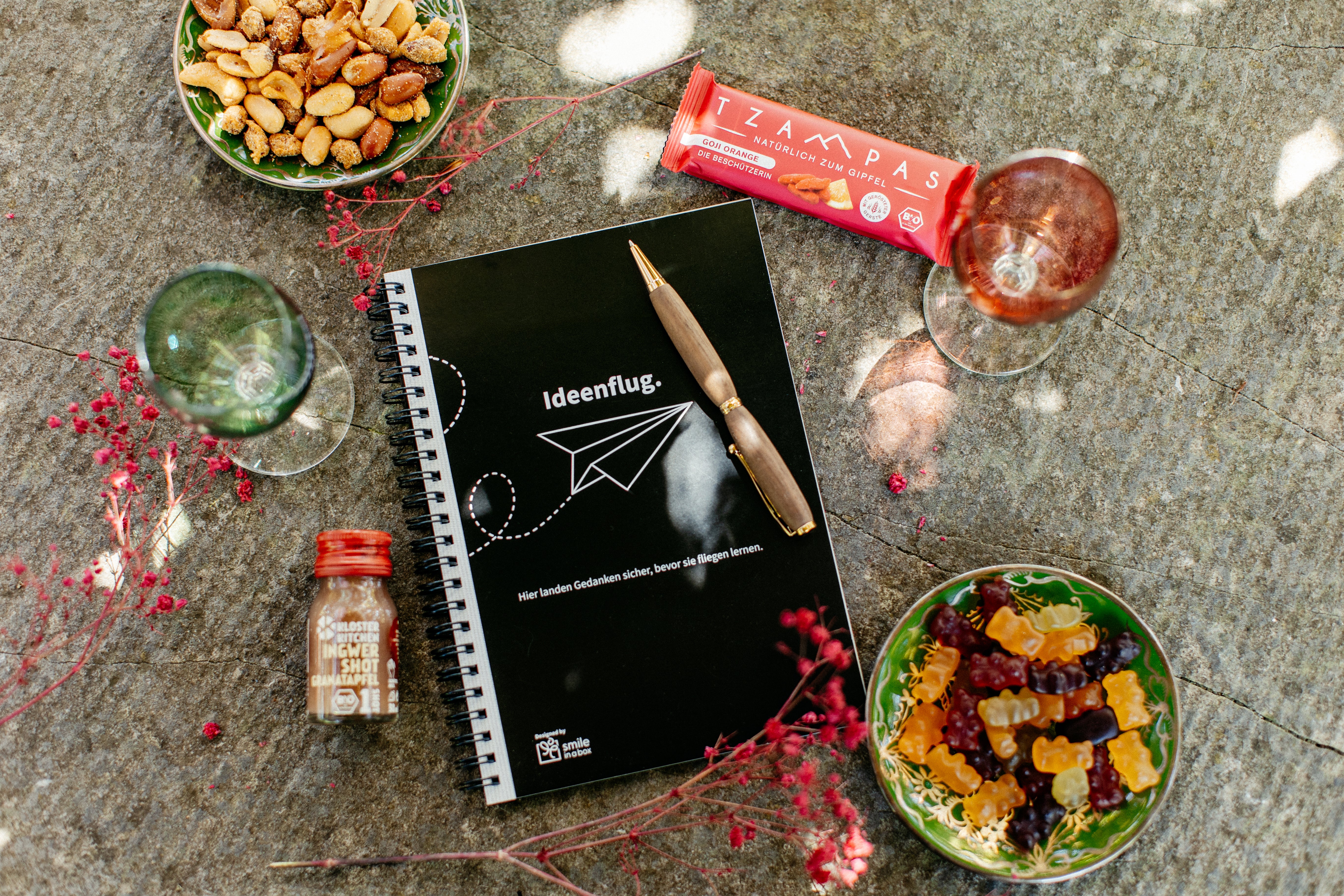 Notizbuch, eleganter Kugelschreiber, Ingwershot und Müsliriegel