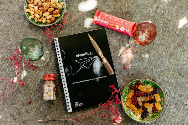 Notizbuch, eleganter Kugelschreiber, Ingwershot und Müsliriegel