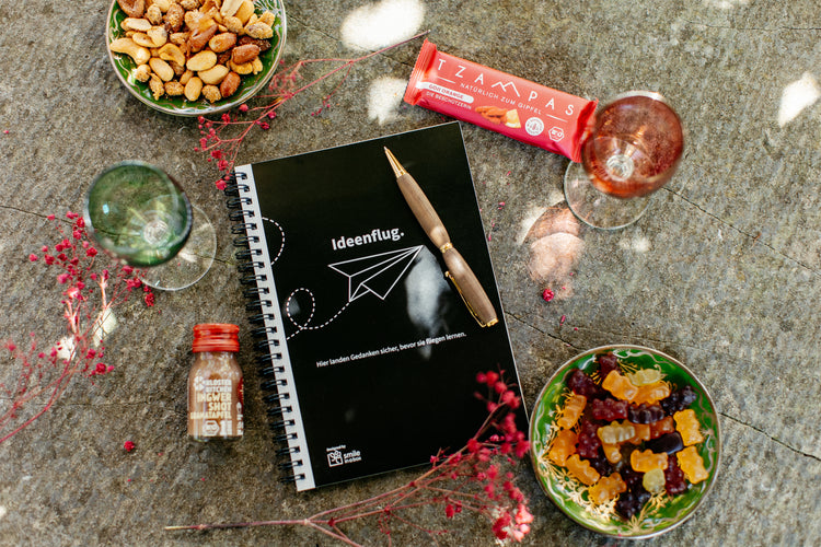 Notizbuch, eleganter Kugelschreiber, Ingwershot und Müsliriegel